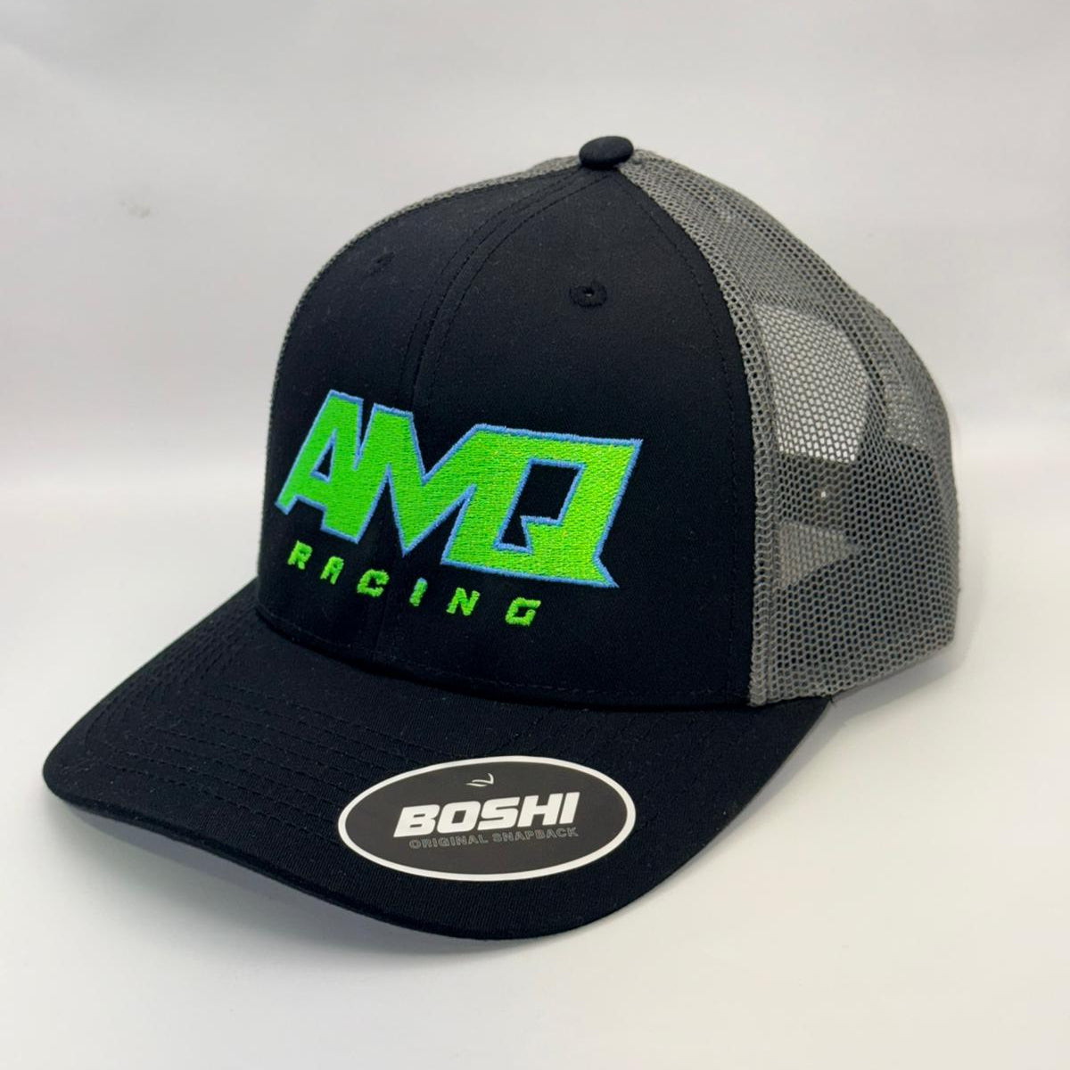 Black and gray cap with green and white logo on a white background